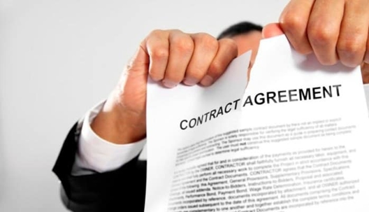 someone ripping up a piece of paper that says contract agreement