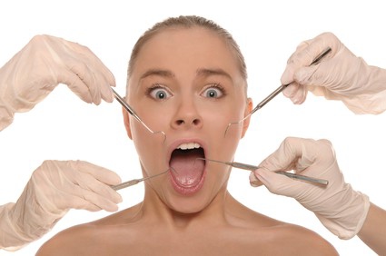 woman with mouth open and dental tools being held on either side